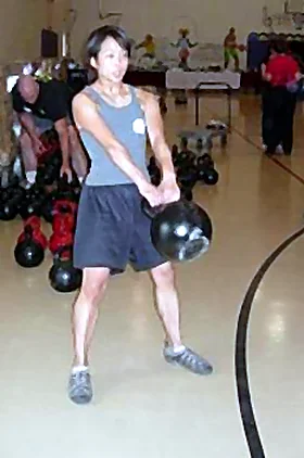 Dr. Courtney Mizuhara-Cheng training with a kettlebell in a gym